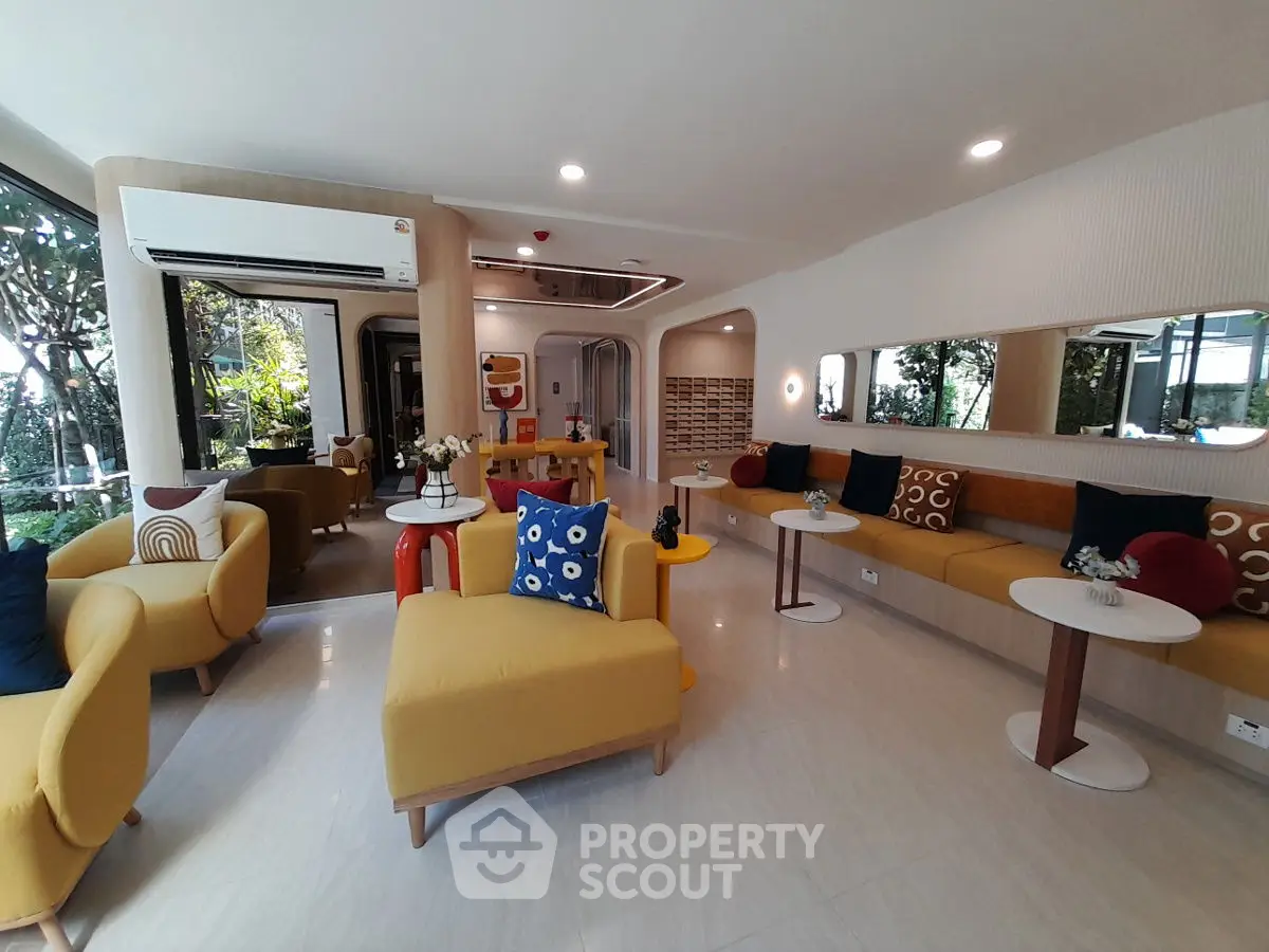 Modern living room with vibrant decor and large windows overlooking greenery.