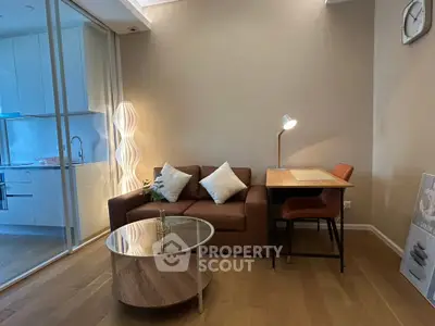 Modern living room with cozy sofa, stylish lamp, and sleek kitchen view
