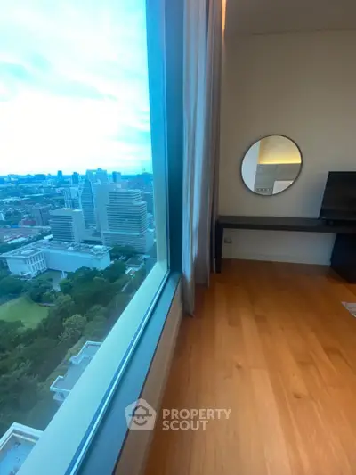 Stunning city view from modern high-rise apartment with wooden flooring and stylish decor.
