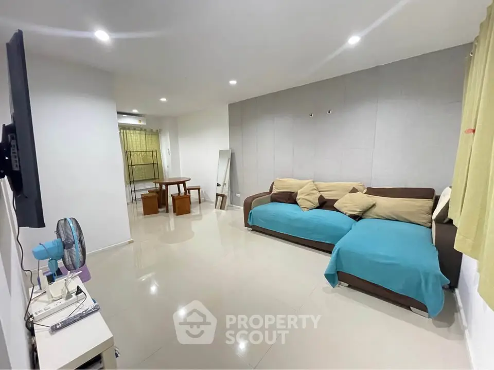 Spacious living room with modern decor and cozy seating area, perfect for relaxation.