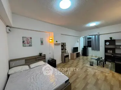 Spacious studio apartment with modern decor and open layout, featuring cozy living area and stylish bedroom.