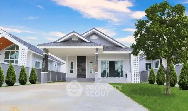 Charming single-story house with spacious driveway and lush green lawn under a clear blue sky.