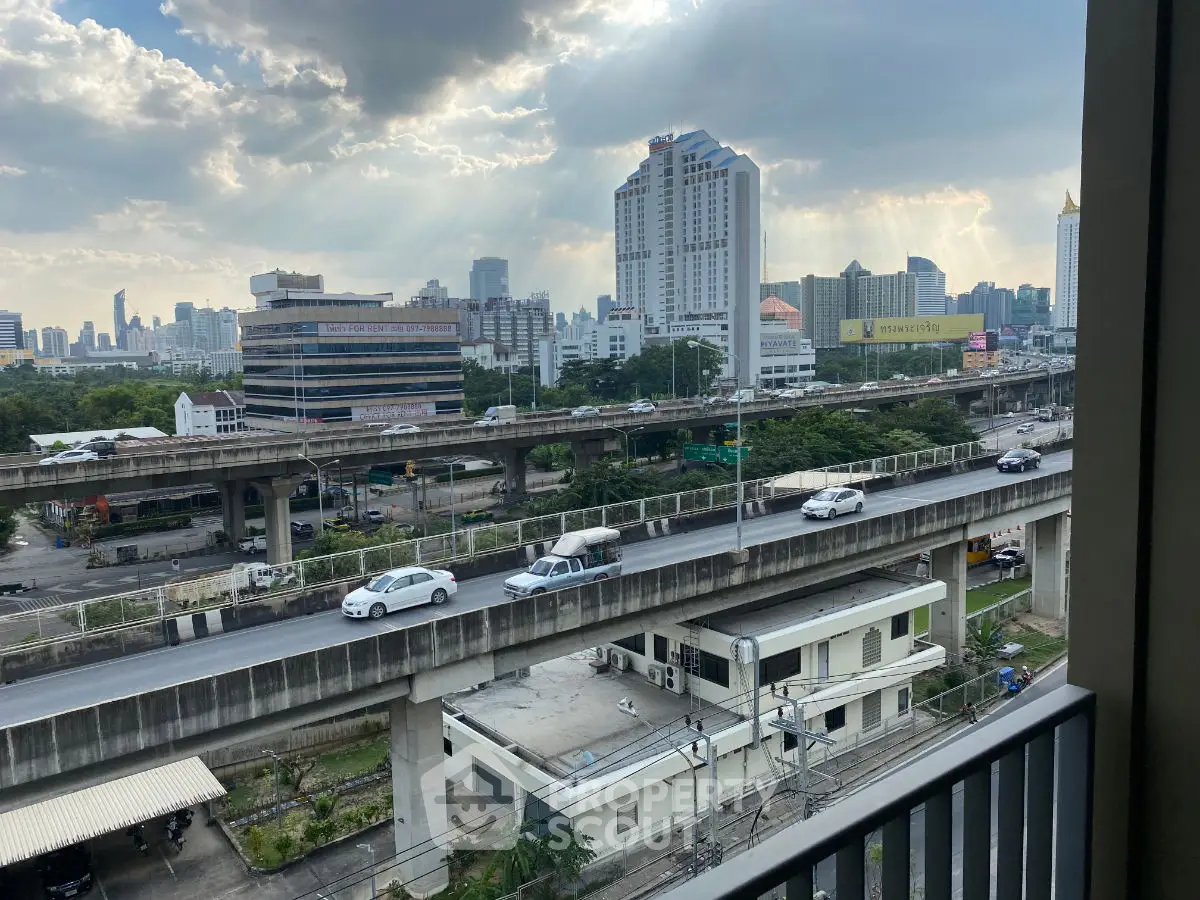 Stunning cityscape view from a high-rise balcony overlooking highways and skyline.