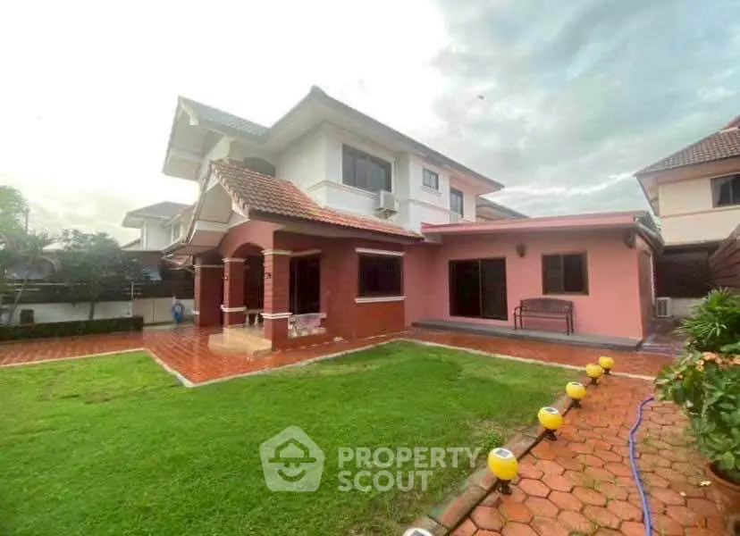 Charming two-story house with spacious garden and tiled patio, perfect for family living.