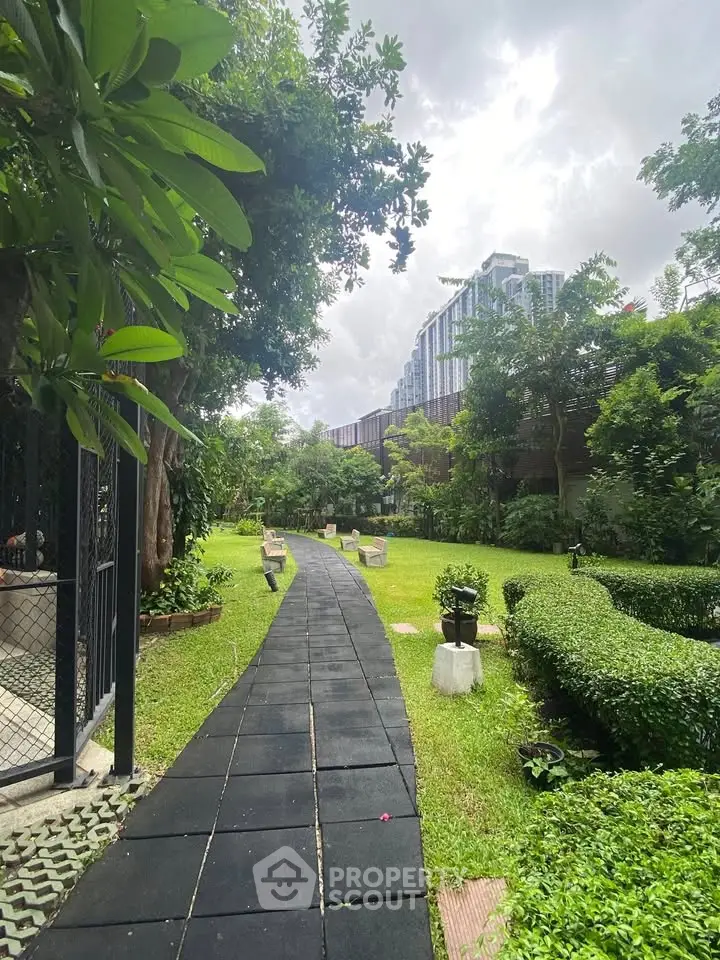 Lush garden pathway in modern residential complex with city views