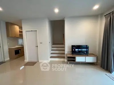 Modern living space with sleek kitchen and cozy TV area