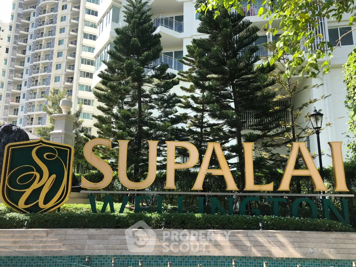 Elegant Supalai Wellington building entrance with lush greenery and modern architecture.