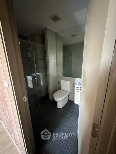 Modern bathroom with sleek design, featuring a glass shower and contemporary fixtures.