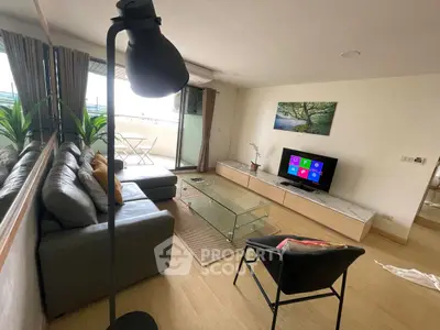 Modern living room with balcony, stylish furniture, and natural light.