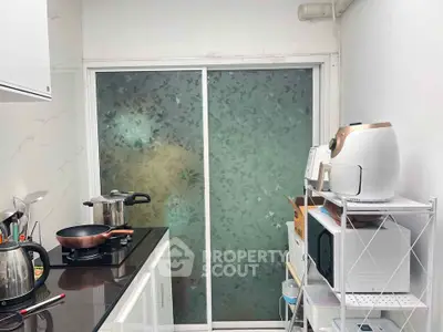 Compact kitchen with modern appliances and frosted glass sliding door