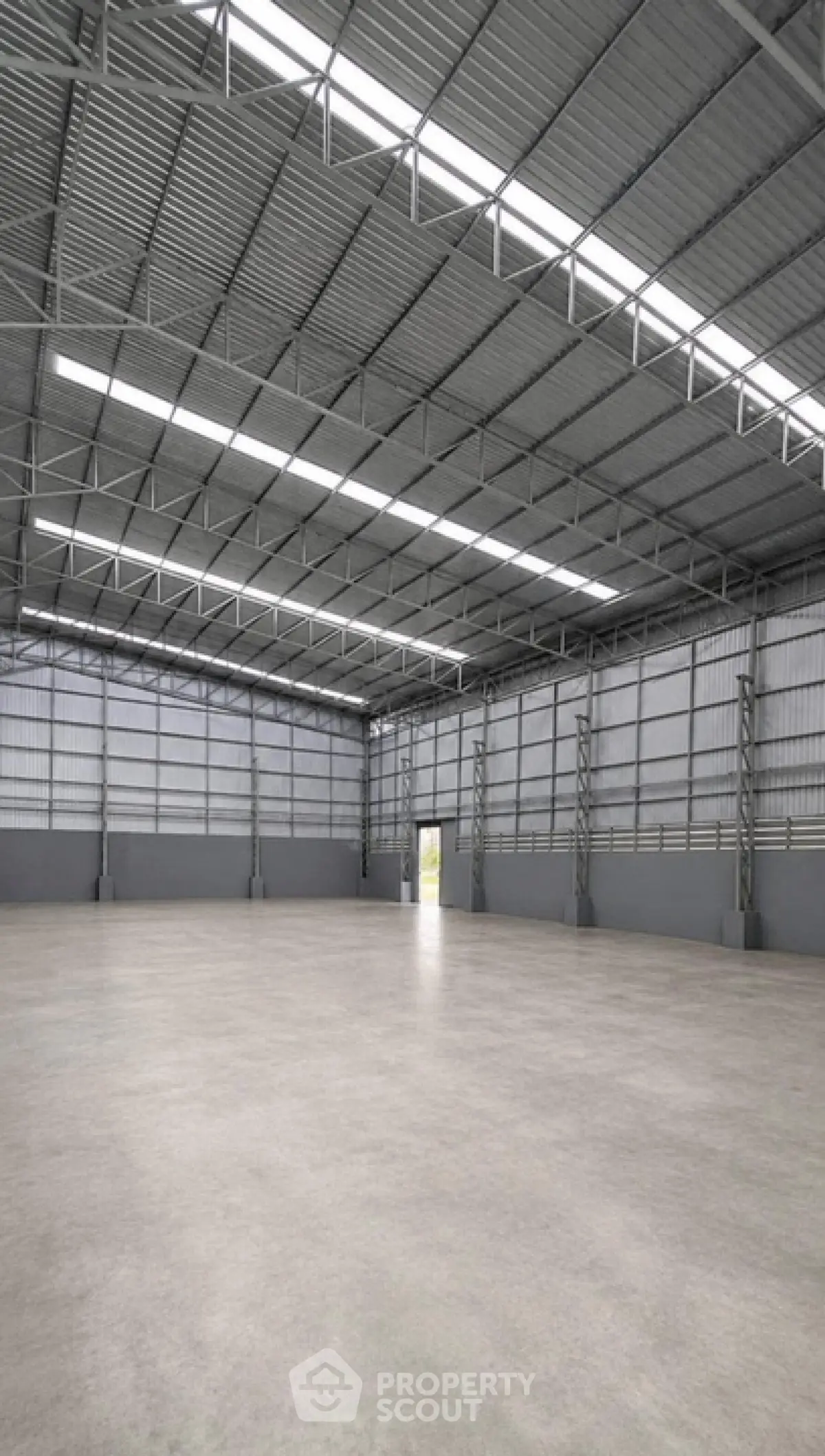 Spacious industrial warehouse with high ceilings and ample natural light, perfect for storage or manufacturing.