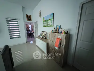 Modern interior hallway with sleek storage and decorative art, leading to a dining area.