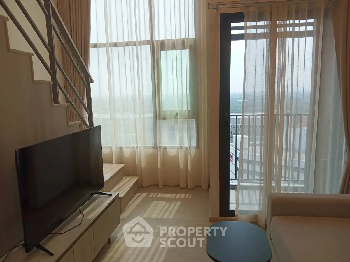 Modern living room with large windows and city view, featuring a sleek TV setup and stylish decor.