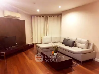 Elegant living room with modern furniture and wooden flooring, perfect for cozy family gatherings.