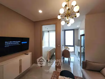 Modern living room with elegant chandelier and view into cozy bedroom