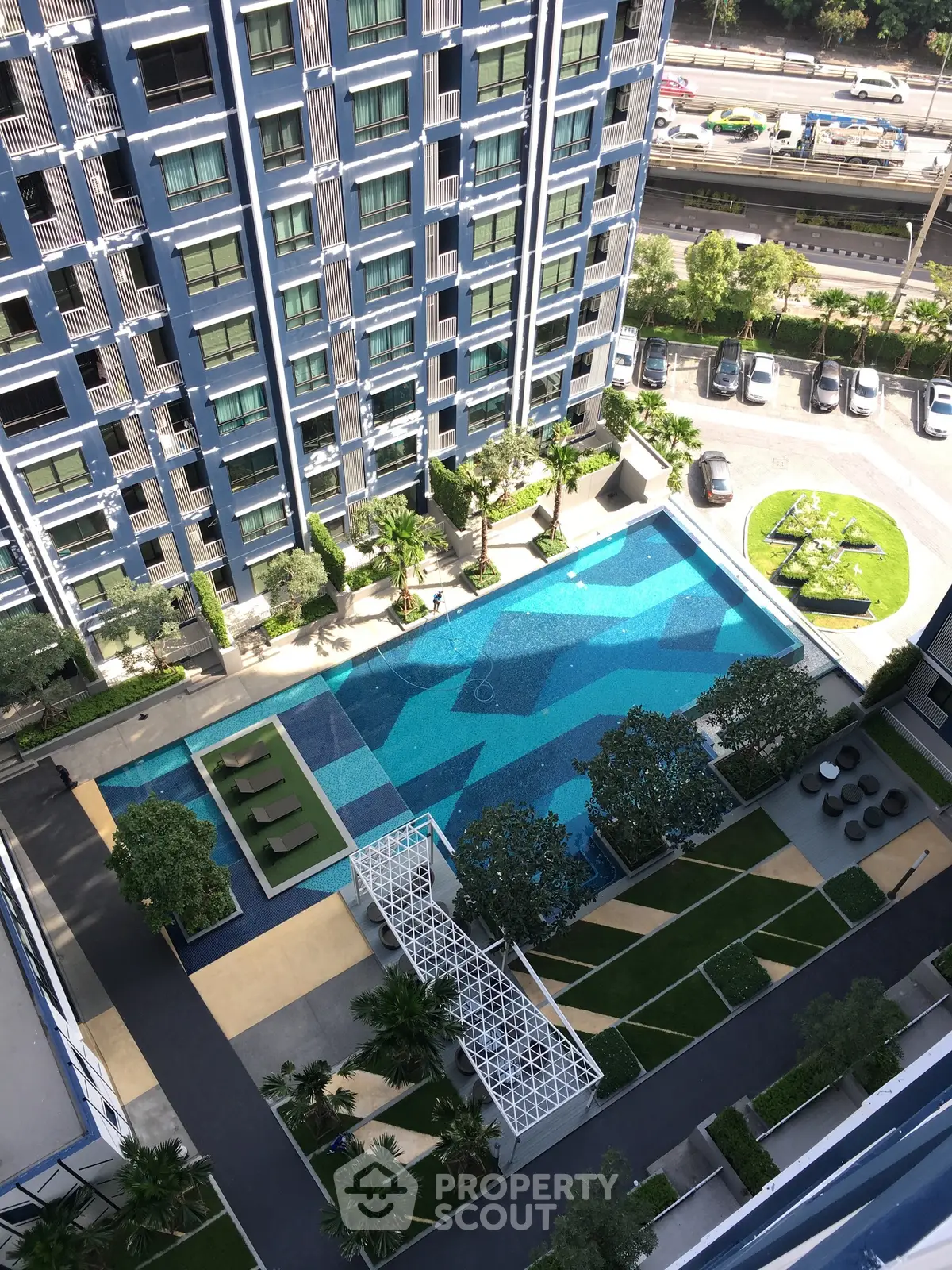 Stunning aerial view of modern residential complex with luxurious swimming pool and landscaped gardens.
