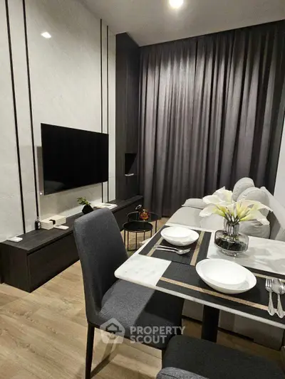Modern living room with elegant dining area and wall-mounted TV, featuring sleek furniture and stylish decor.