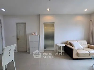 Modern living room with sleek furniture and minimalist design, featuring a cozy sofa and stylish decor.