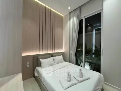 Modern bedroom with elegant lighting and large window overlooking greenery.