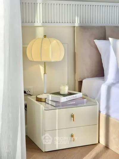 Elegant bedroom nightstand with stylish lamp and decor books, creating a cozy and inviting atmosphere.