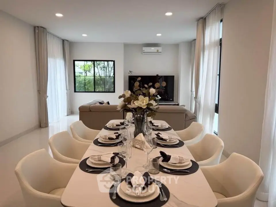 Elegant dining area with modern decor and cozy living room in open layout