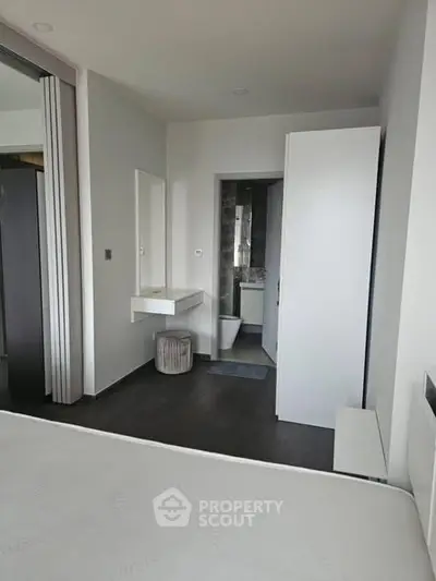 Modern minimalist bedroom with ensuite bathroom and sleek design.