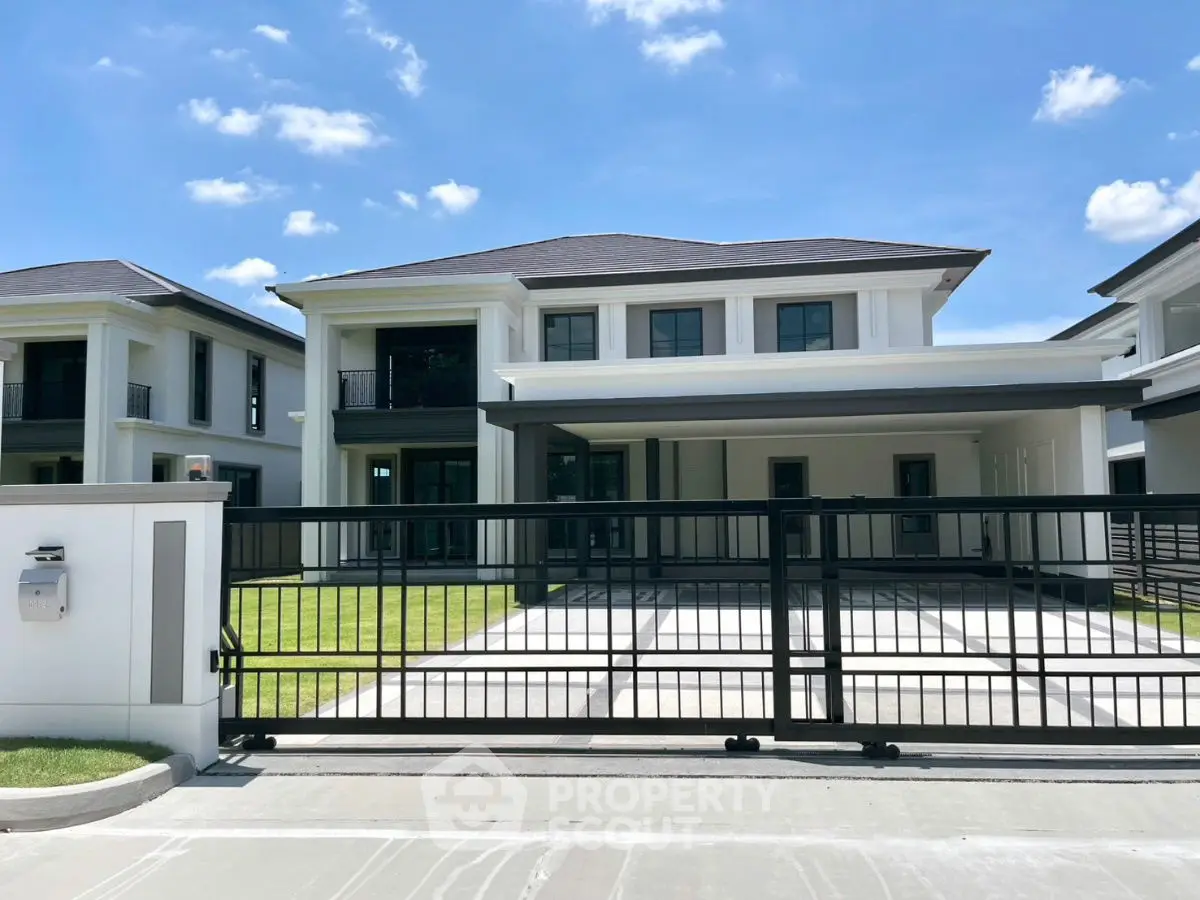 Luxurious modern house with spacious driveway and elegant design under clear blue sky.