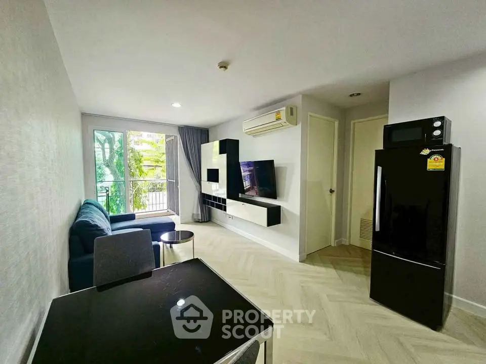 Modern living room with sleek furniture and balcony view in a stylish apartment.