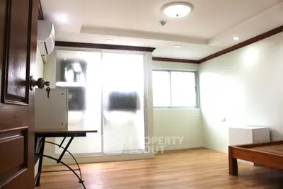 Bright and airy room with wooden flooring and modern lighting, ideal for versatile use.