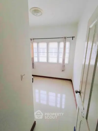 Bright room with large windows and glossy tiled floor, perfect for natural light lovers.