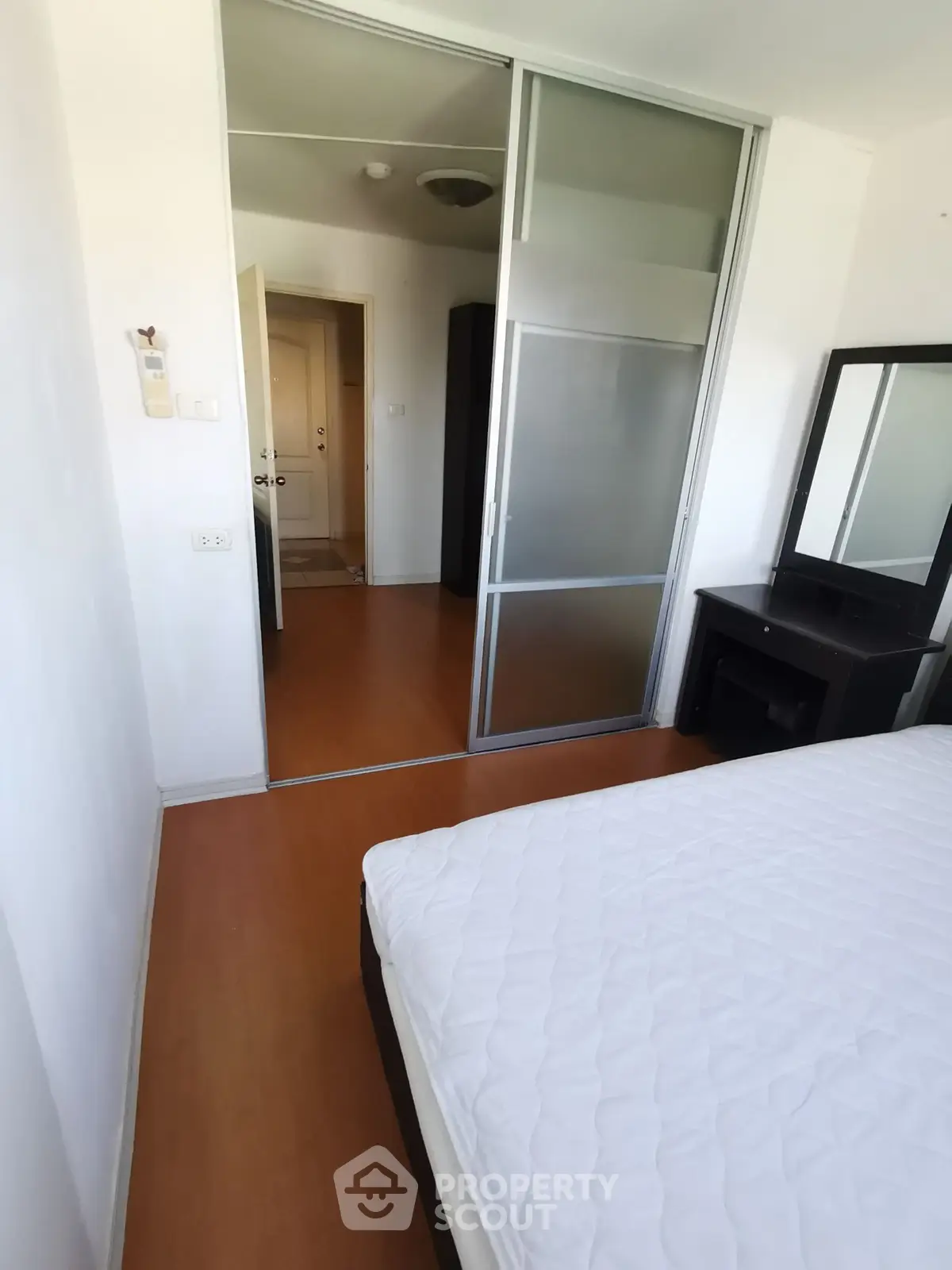 Cozy bedroom with sliding glass door and wooden flooring