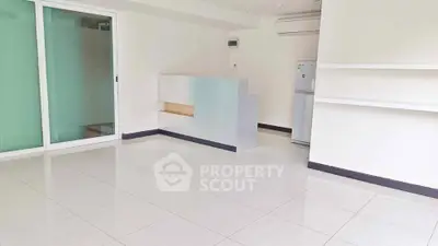 Spacious modern living room with sleek tile flooring and minimalist design.