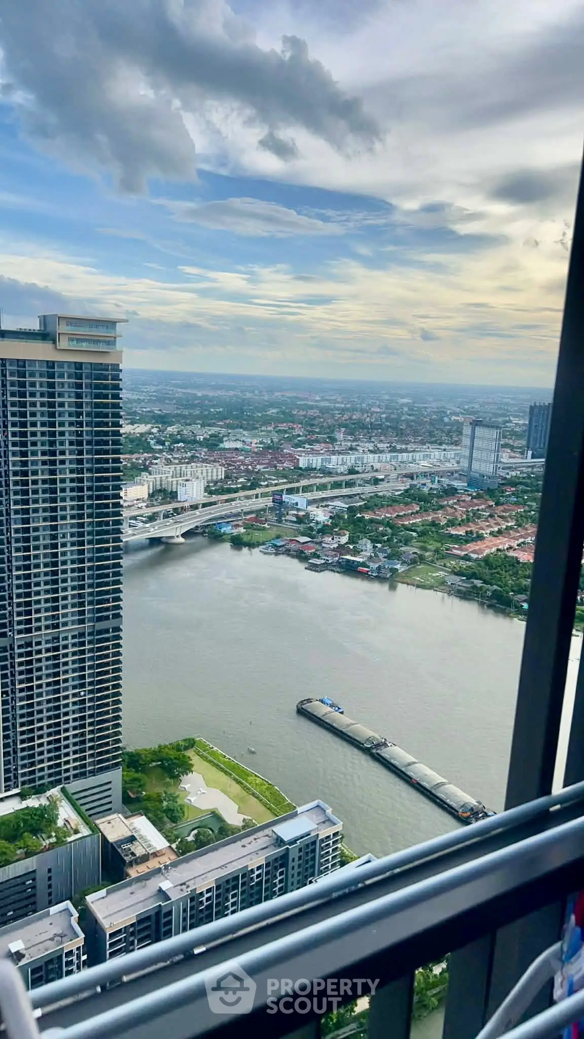 Stunning high-rise river view from a modern balcony, showcasing urban skyline and serene waterway.