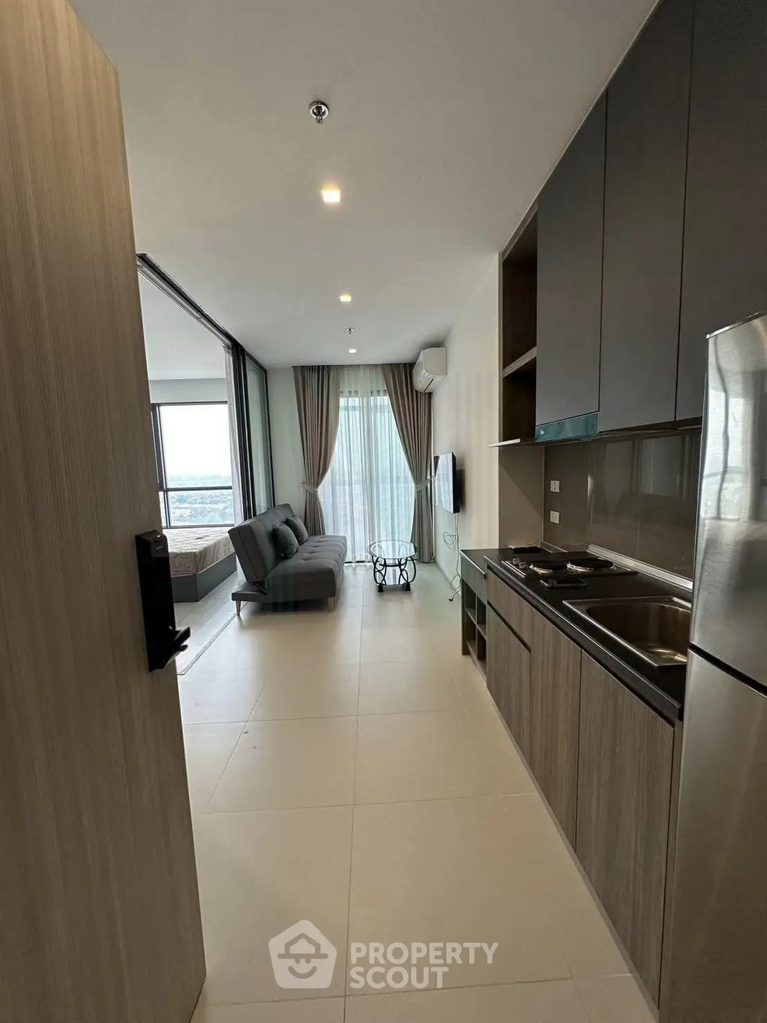 Modern open-layout kitchen and living room with sleek design and large windows offering a stunning view.