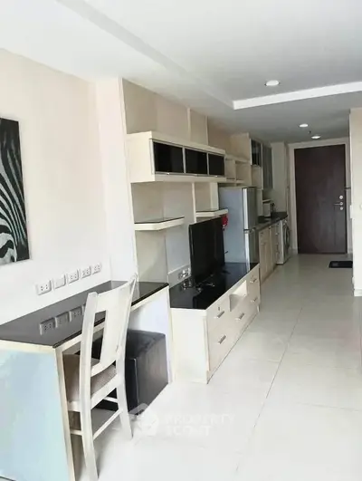 Modern living room with sleek furniture and integrated kitchen appliances in a stylish apartment.