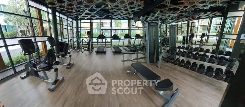 Modern gym with state-of-the-art equipment and large windows offering a scenic view.
