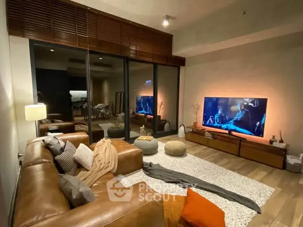 Luxurious living room with leather sofa, large TV, and cozy decor for ultimate relaxation.
