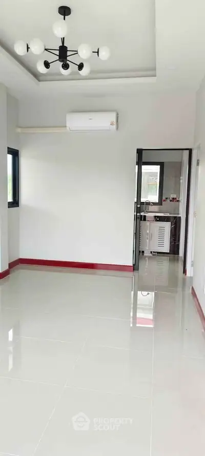 Spacious unfurnished room with modern lighting and air conditioning, ideal for customization.