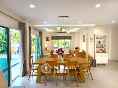 Spacious dining area with pool view and elegant wooden furniture