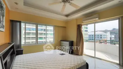 Spacious bedroom with balcony and city view, featuring modern design and ample natural light.
