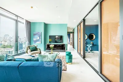 Luxurious modern living room with stunning city view, elegant blue decor, and spacious open layout.