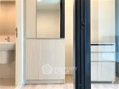 Modern bathroom with sleek cabinetry and sliding glass door in a contemporary apartment.