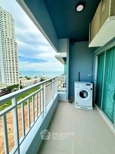 Spacious balcony with ocean view and washing machine in a high-rise apartment.