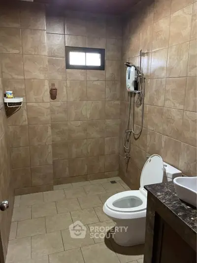 Spacious bathroom with modern fixtures and tiled walls