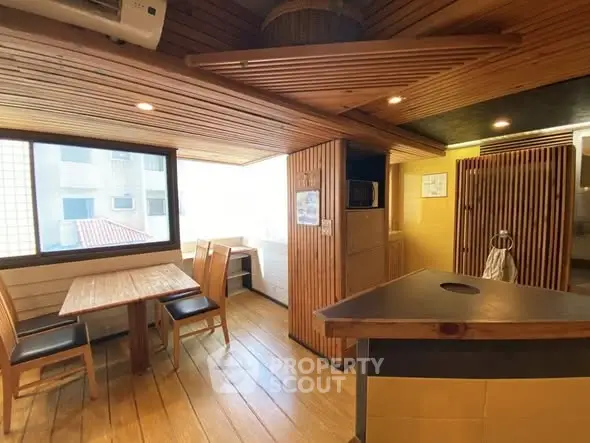 Charming wooden interior with dining area and modern kitchen in cozy apartment.