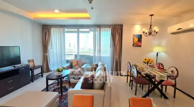 Spacious living room with elegant dining area and large windows offering natural light.