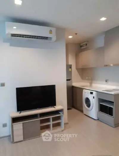 Modern apartment interior with sleek kitchen and living area featuring air conditioning and appliances.