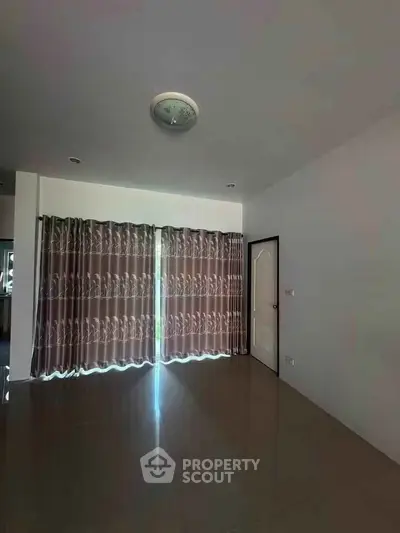 Spacious room with elegant curtains and glossy floor, perfect for modern living.