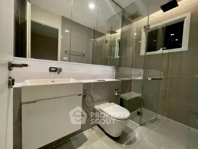 Modern bathroom with sleek design, glass shower, and contemporary fixtures in a stylish real estate property.