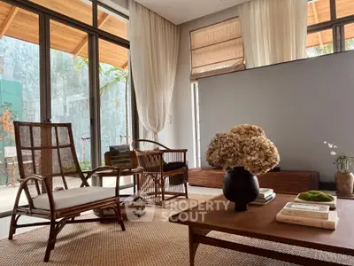 Chic living room with natural light, stylish rattan furniture, and elegant decor in a modern home.